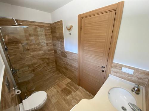 a bathroom with a shower and a toilet and a sink at Villa Merry - Dalyan Stonehouse with Palmtrees, 50m to River in Ortaca