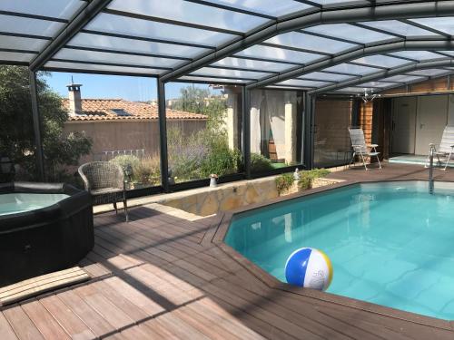 une piscine avec une pergola et une piscine avec une terrasse dans l'établissement Chambre d hôtes AU CŒUR DES OLIVIERS, à Marseille