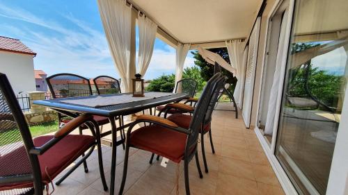 - une terrasse couverte avec une table et des chaises sur un balcon dans l'établissement Apartments Manuel, à Rab