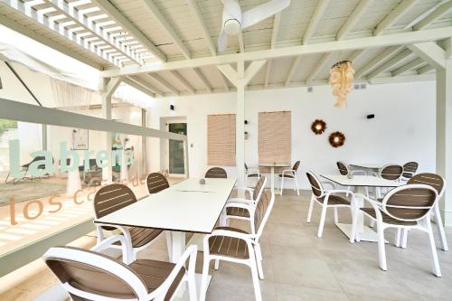 a dining room with white tables and chairs at Labreña Hotel in Los Caños de Meca