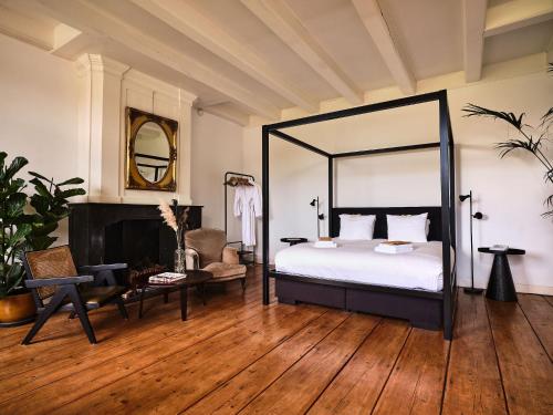 a bedroom with a large bed and a fireplace at Eco Hotel Plantage Rococo in Velsen-Zuid