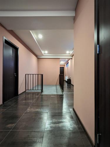 an empty hallway with pink walls and tile floors at Milky Way in Stepantsminda