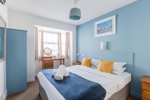 1 dormitorio con 1 cama grande y paredes azules en Brooklands, en Bournemouth