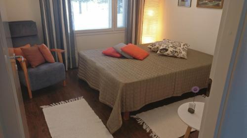 1 dormitorio pequeño con 1 cama y 1 silla en Holiday Villa Tonkokumpu - upea loma-asunto, en Syöte