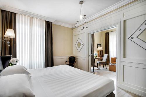 a hotel room with a bed and a dresser at Relais Santa Croce, By Baglioni Hotels in Florence