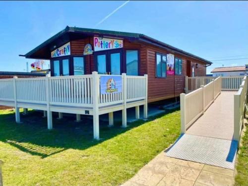 a small house with a white fence around it at Lodge Sleeps 8- Parking Wifi Campsite Amenities in Jaywick Sands