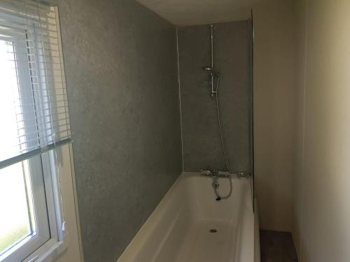 a bathroom with a shower and a bath tub at St Osyth New Holiday Home in Jaywick Sands