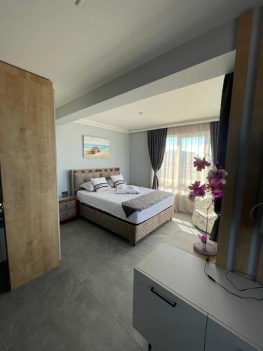 a bedroom with a bed and a large window at Апартаменти Генезис Ахтопол in Ahtopol