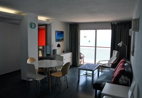 a living room with a couch and a table and chairs at Al despertar ver el mar in Benidorm