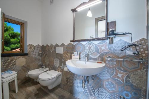 a bathroom with a sink and a toilet and a mirror at Il Casale del Contadino in Agerola