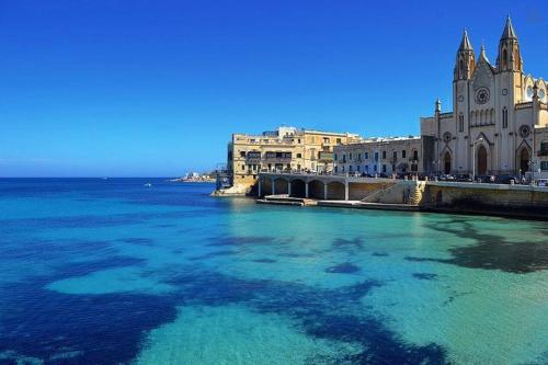 a view of the water in front of a building at Central Family Apartment in Valletta