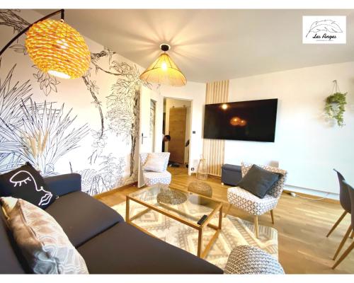 uma sala de estar com um sofá, cadeiras e uma mesa em L'Eden - 2 chambres - Centre ville - ASCENSEUR em Arras