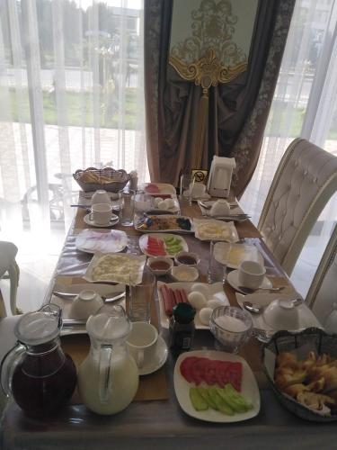 a long table with plates of food on it at Panjakent Plaza in Panjakent