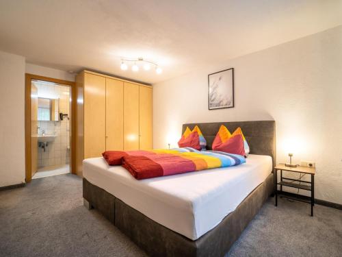 een slaapkamer met een groot bed met kleurrijke kussens bij Haus Felder in Gortipohl