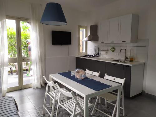 uma cozinha com mesa e cadeiras e uma cozinha com lavatório em Villa Giulio em Fondachello