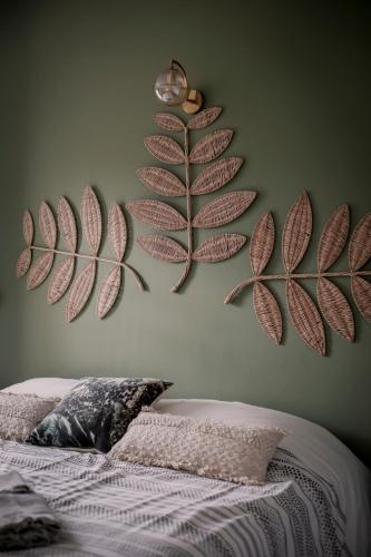 a bedroom with two large leaves on the wall at Les Hauts de Diane, CUERS var in Cuers