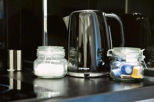 a coffee pot and jars of milk on a counter at EPaN Luxury Apartments in Thessaloniki