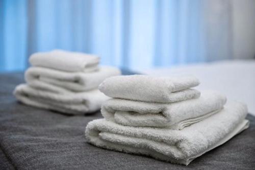 een stapel handdoeken bovenop een bed bij EPaN Luxury Apartments in Thessaloniki