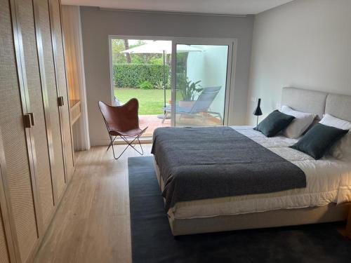 a bedroom with a bed and a patio with a chair at Victory Village 10C in Quinta do Lago