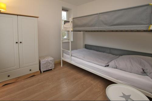 a bedroom with a bunk bed and a desk at But Doerp 3_ Whg_ 3 in Wyk auf Föhr