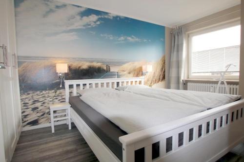 - une chambre avec un lit et une fresque murale représentant la plage dans l'établissement Feldstr_ 18_ _Nordmeer_ Whg_ E2, à Wyk auf Föhr