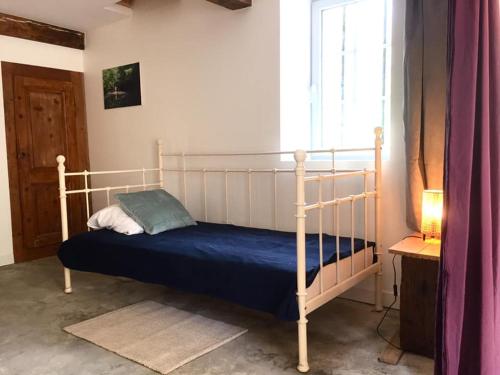 a bedroom with a bed with a blue blanket at Les pieds dans l'eau- gîte l'Estancot-plage privée in Blacons