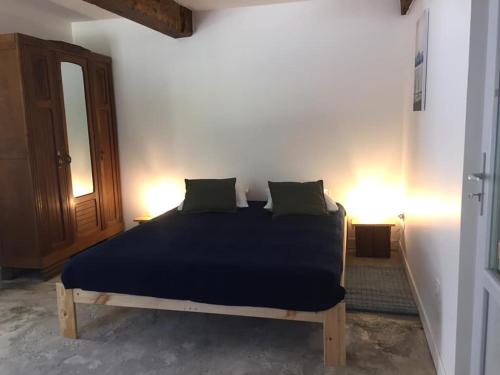 a bedroom with a bed with blue sheets and pillows at Les pieds dans l'eau- gîte l'Estancot-plage privée in Blacons