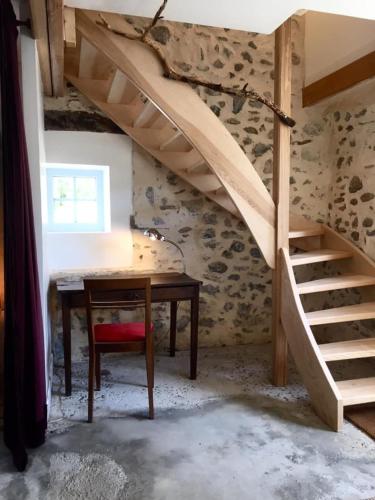a room with a wooden desk and a staircase at Les pieds dans l'eau- gîte l'Estancot-plage privée in Blacons