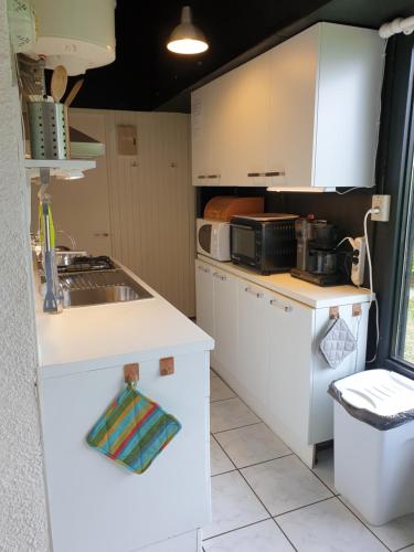 een keuken met witte kasten en een spoelbak bij Gardameer-Tignale-Hasewinkel in Tignale