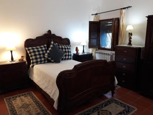 een slaapkamer met een groot bed en een televisie bij Monte da Pega (Guest House) in Monsaraz