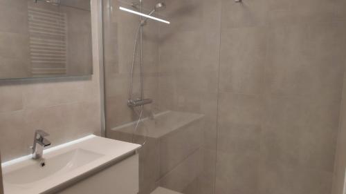 bagno con doccia e lavandino bianco di Blutsyde Promenade Encanto a Bredene