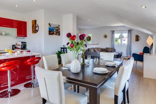 a kitchen and dining room with a table and chairs at Apartman ViEw in Preko