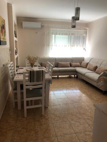 sala de estar con mesa y sofá en Bellavista Qerret Apartments, en Golem