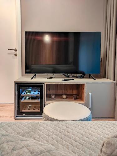 a living room with a large flat screen tv at Comfy Rest apartamentai Kalno namuose in Juodkrantė