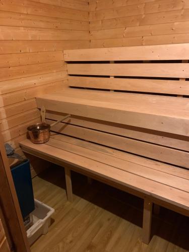 a wooden bench in a sauna with a bowl on it at Hotel Repvåg in Repvåg