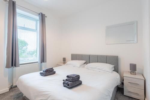 a bedroom with a bed with two suitcases on it at Hilltown Apartment in Dundee