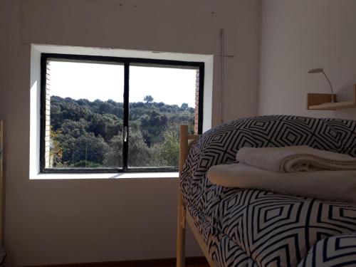 um quarto com uma janela e uma cama com vista em Albergue Alagón Natura em Valdeobispo