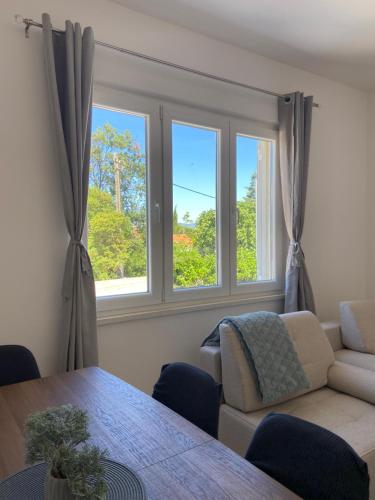 a living room with a couch and two windows at Cherry in Korčula