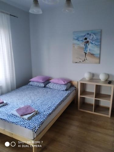 a bedroom with a bed and a picture of a beach at mieszkanie na wrzosowej in Kruklanki