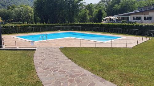 - une piscine dans une cour à côté d'une maison dans l'établissement Appartamento IRIS, à Spinone Al Lago