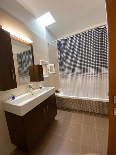 a bathroom with a sink and a shower and a tub at Koundouros Home in AmigdhalokeFálion