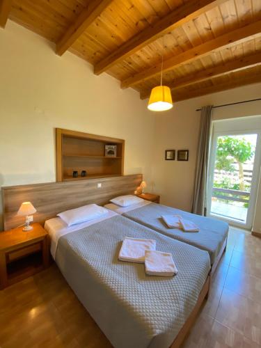 a bedroom with a bed with two towels on it at Koundouros Home in AmigdhalokeFálion