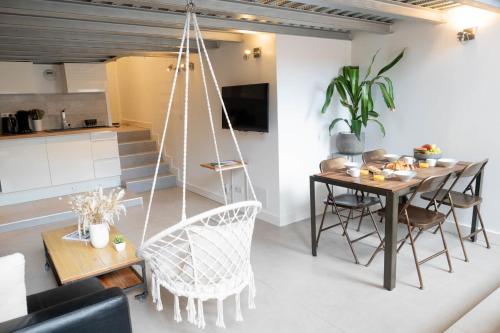 - un salon avec une table, des chaises et une balançoire dans l'établissement Loft Gramont  Cozy Studio - au calme - centre ville - tout à pied, à Biarritz