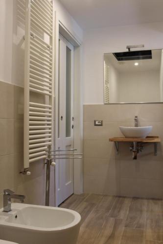 a white bathroom with a sink and a mirror at Serendipity House in Grosseto