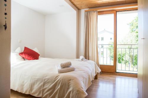 um quarto com uma cama branca e uma grande janela em Zwei Zimmer Ferienwohnung Rabiusa Churwalden em Churwalden