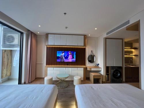 a bedroom with two beds and a flat screen tv at Apec Mandala Phú Yên Hương Giang Condotel in Liên Trì (3)