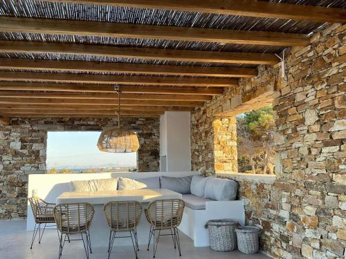 a living room with a couch and a table and chairs at Sorokos Villa Panagia beach in Andiparos