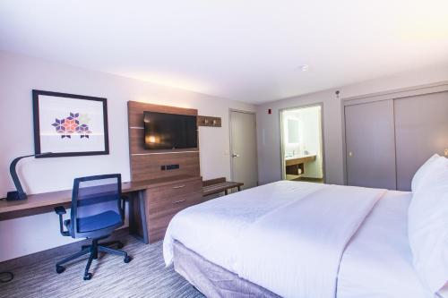 a hotel room with a bed and a desk and a television at Holiday Inn Express & Suites - Lincoln East - White Mountains by IHG in Lincoln