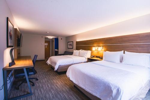 a hotel room with two beds and a desk at Holiday Inn Express & Suites - Lincoln East - White Mountains by IHG in Lincoln