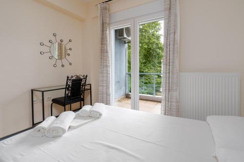 a white bedroom with a bed and a window at Villa Dias in Leptokarya